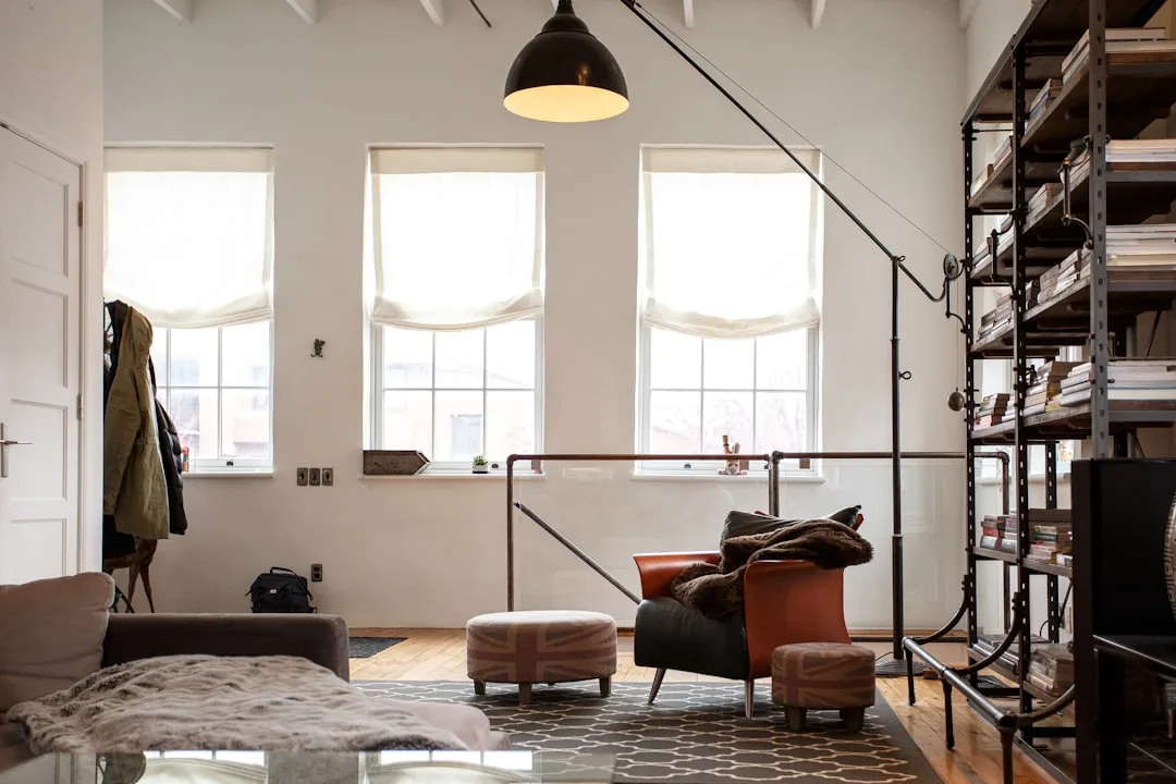 Industrial loft living room mixing leather chair, metal shelving, and vintage lamp with cozy textiles and Union Jack ott