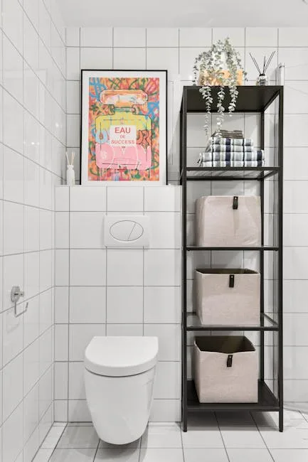 Black metal etagere shelf with linen storage baskets and folded towels next to wall-mounted toilet in white tiled bathro