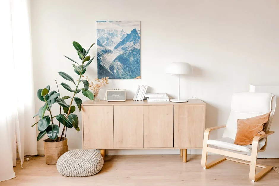 Scandinavian living room with light wood sideboard, IKEA Poäng chair, rubber plant, and mountain wall art