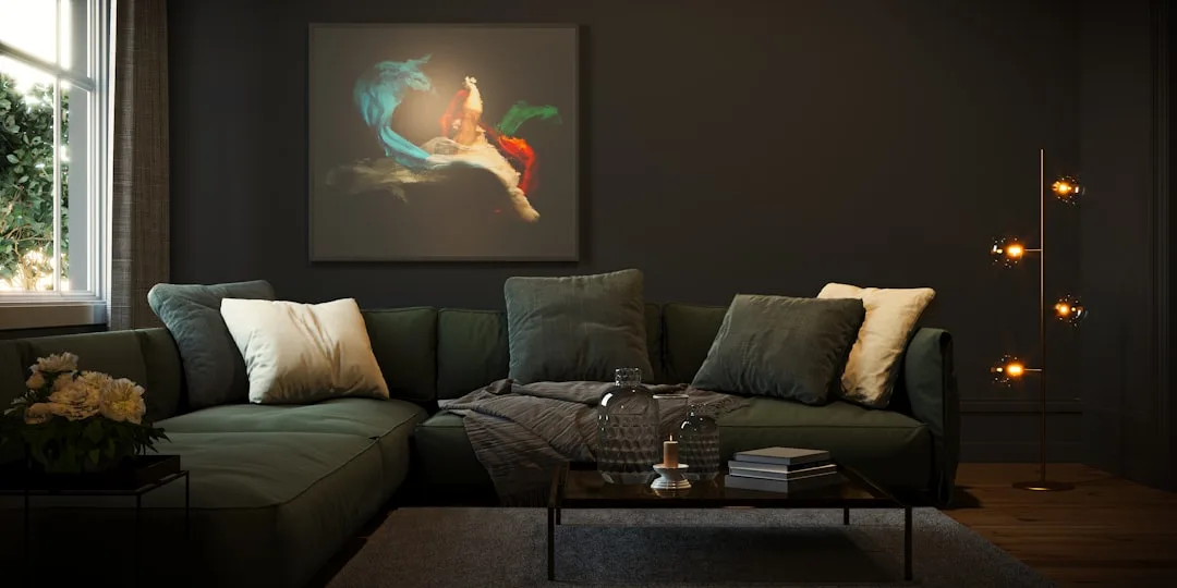 Dark living room with framed artwork lit above green sofa, floor lamp with globe lights beside coffee table