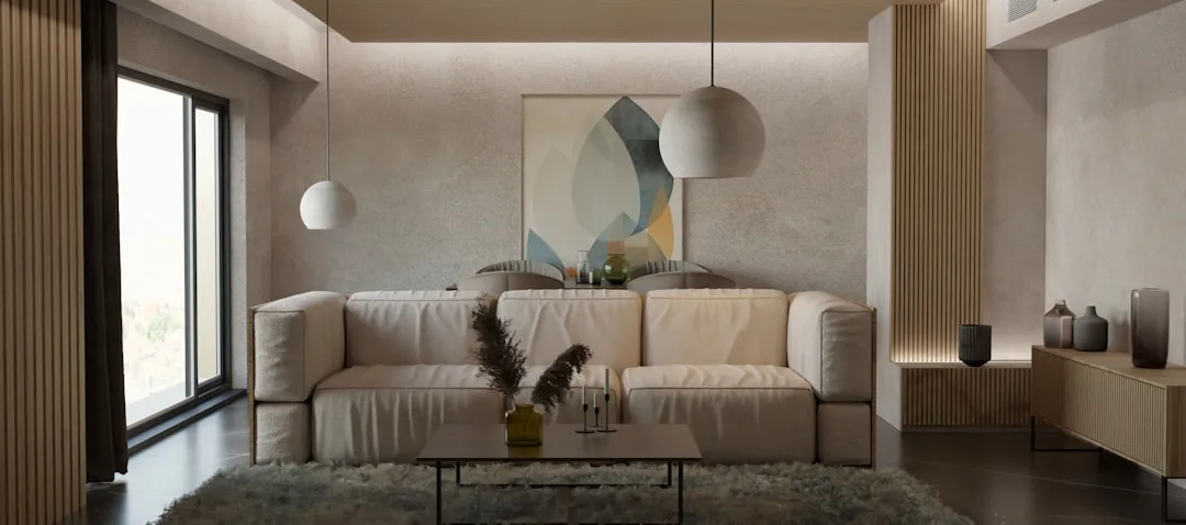 Modern living room with neutral beige sofa, warm-toned walls, and pendant lighting demonstrating a cohesive neutral pale