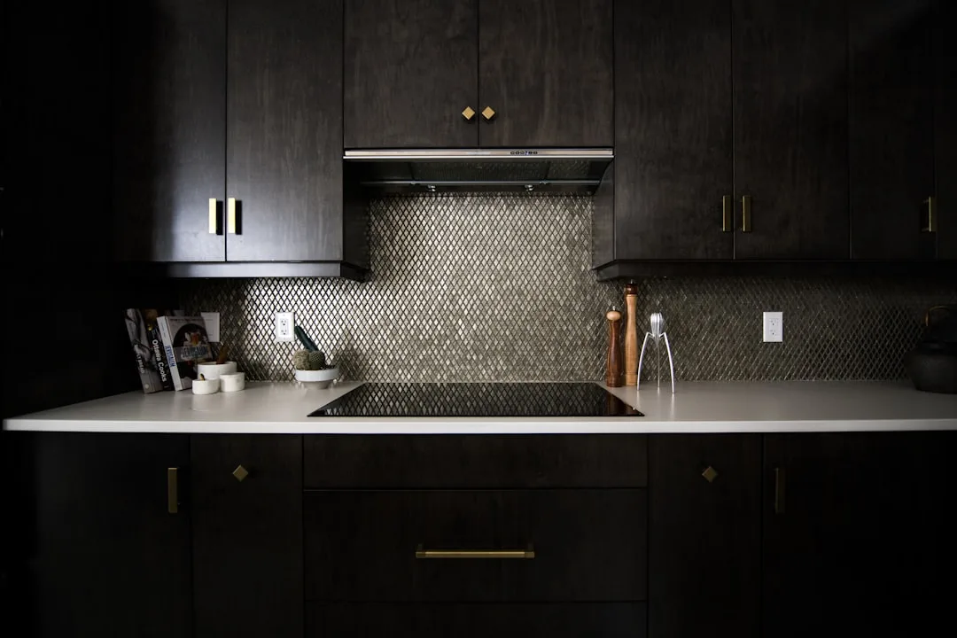 Dark espresso kitchen cabinets with white quartz countertops and gold hardware showing light-dark contrast design