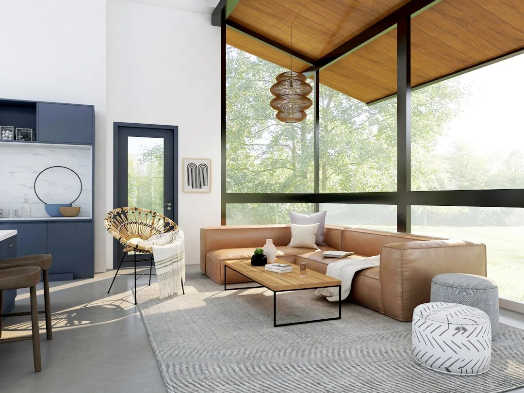 Modern living room with floor-to-ceiling windows flooding natural light onto leather sectional sofa and wood coffee tabl