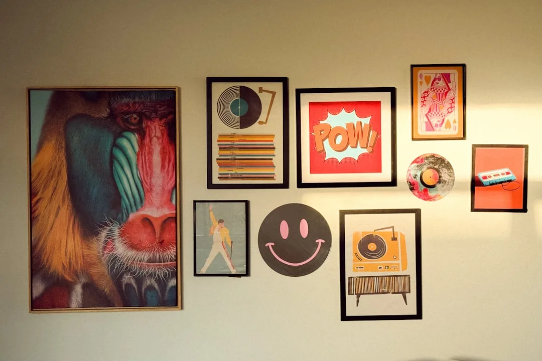Gallery wall arrangement with colorful framed art prints including pop art, vinyl records, and a mandrill portrait