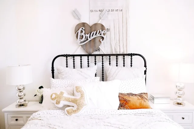 White queen bed with black iron headboard, layered