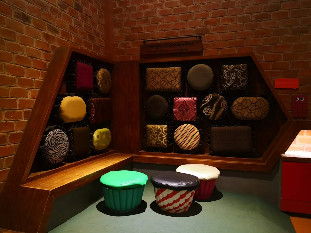 Chocolate box themed wall display with decorative cushions and cupcake stools serving dual storage and decor purpose