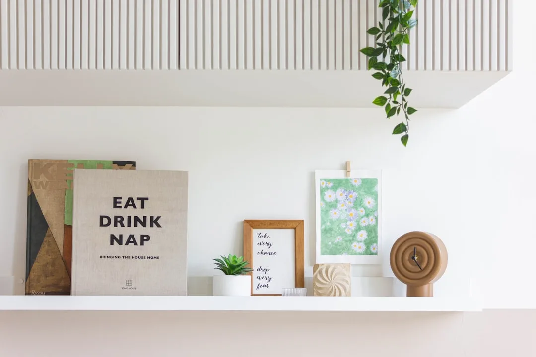 Minimalist shelf styling with Eat Drink Nap book, small succulent, framed quote, daisy artwork and wooden clock