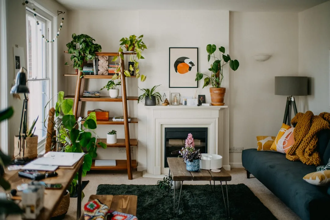 Wooden ladder shelf with plants and books beside fireplace in cozy living room showing shelf placement mistakes
