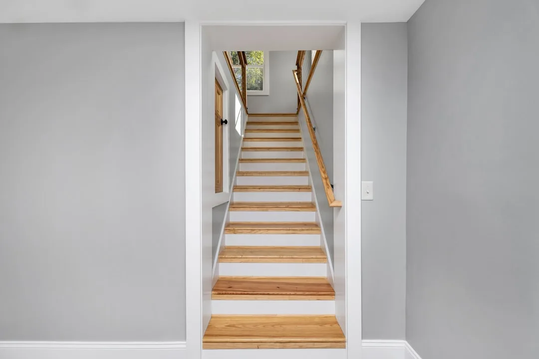Basement staircase with wood treads and white risers leading to upper floor through doorway opening