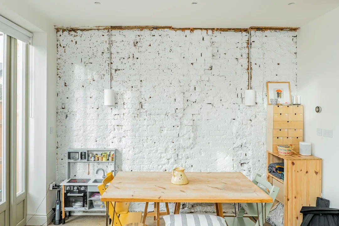 DIY accent wall with white-painted exposed brick showing common mistakes like peeling paint and unfinished edges