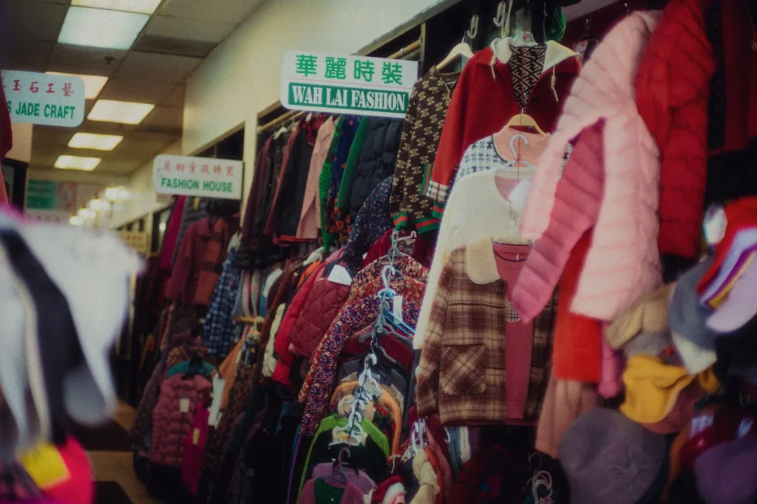 Crowded thrift store clothing racks with colorful garments at Wah Lai Fashion market stall