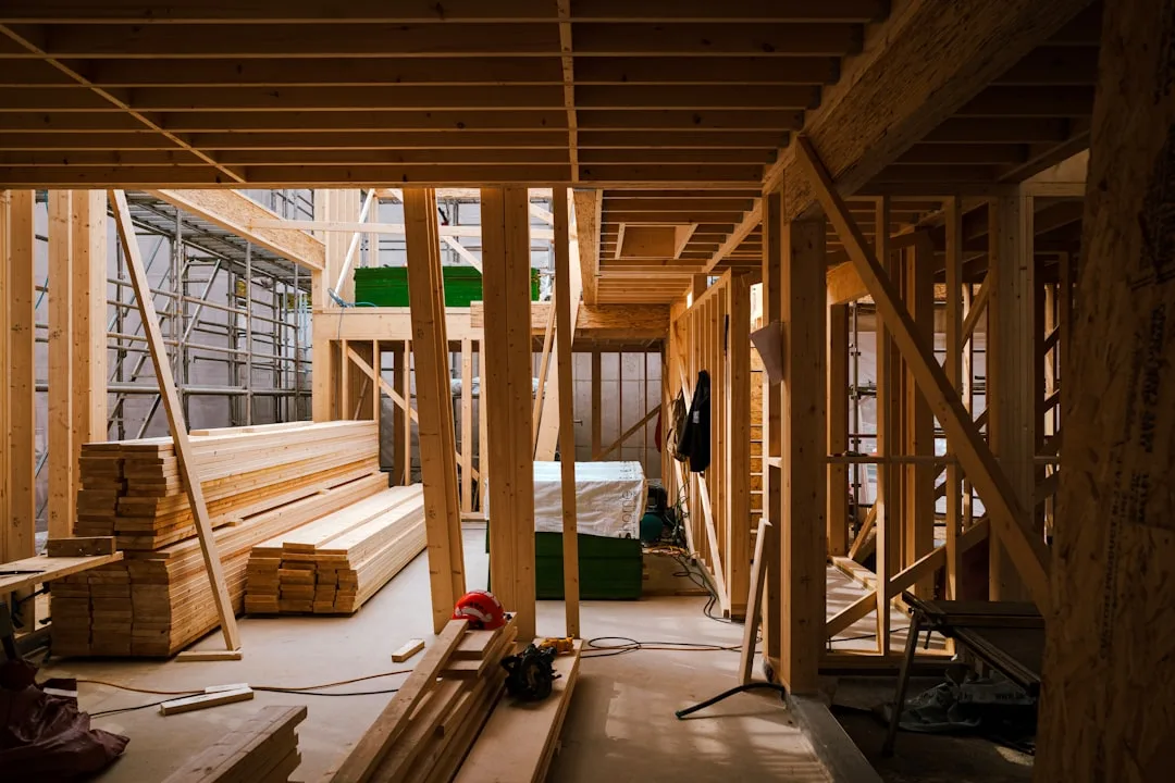 Interior wood framing and structural beams during residential construction showing load-bearing wall and floor system