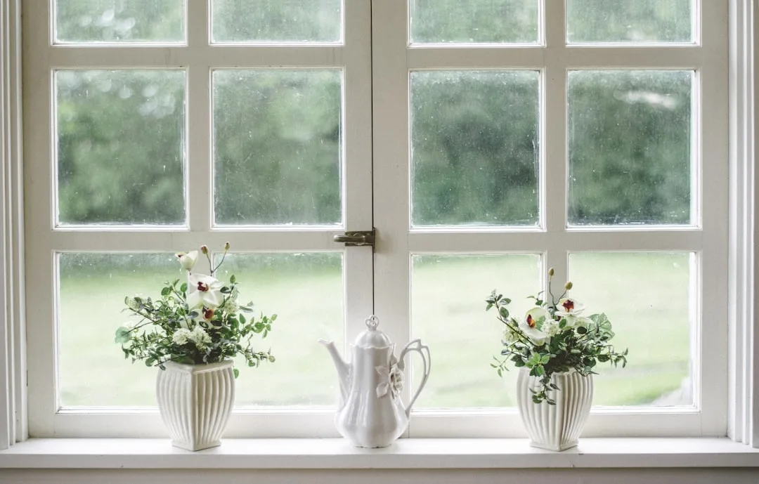White French window with decorative white vases and teapot on windowsill showing window design details