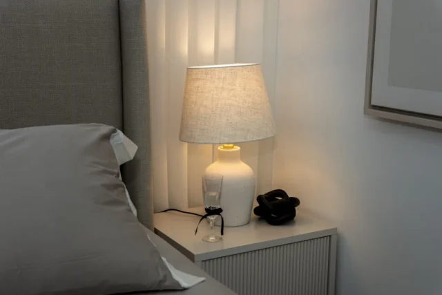 A bedside table with a lamp and decor.