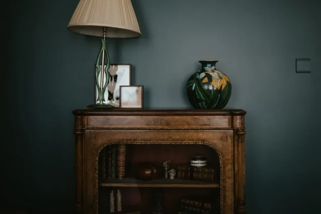 a table with a lamp and a vase on top of it