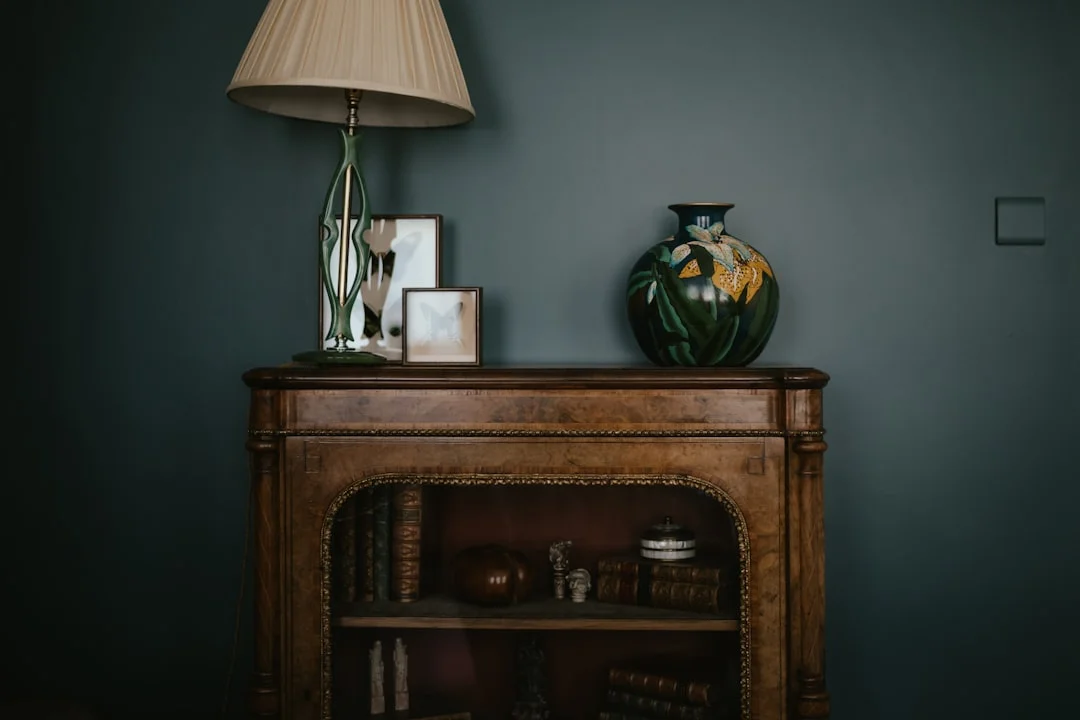 a table with a lamp and a vase on top of it