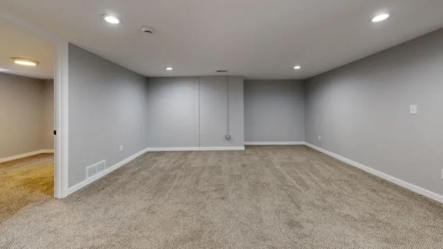Empty finished basement with gray walls, recessed