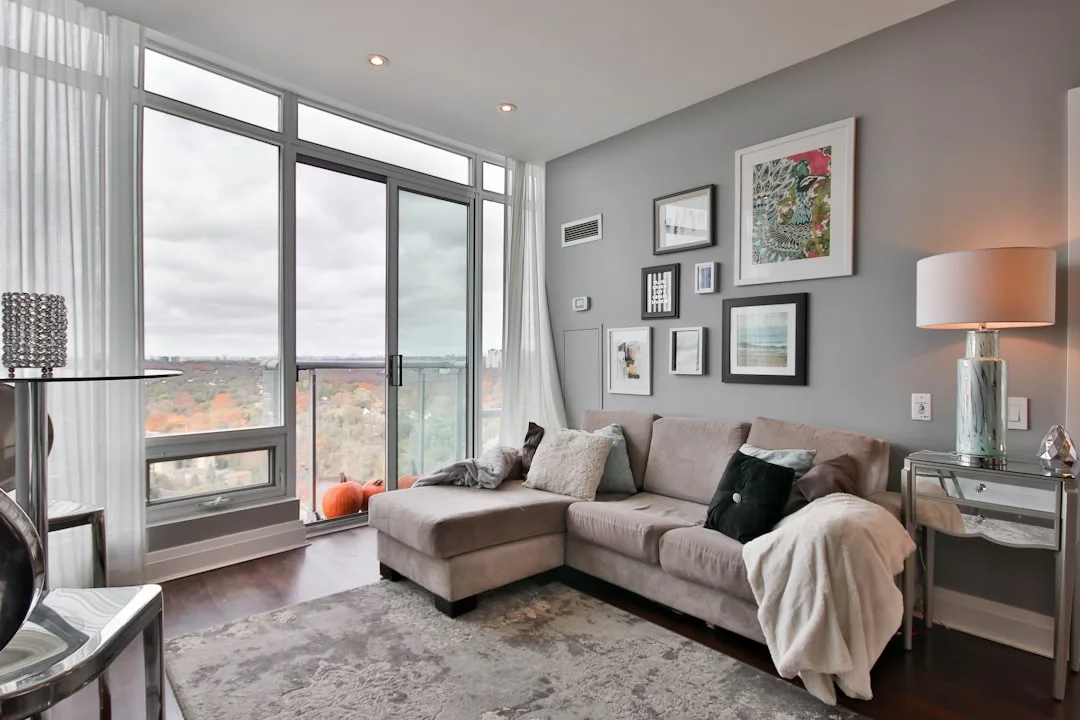 Modern living room with sectional sofa, gallery wall groupings, and fall pumpkin decor demonstrating the rule of three i
