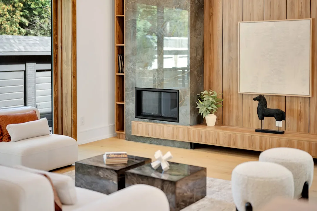 Modern living room with defined seating zone, marble fireplace, and wood-paneled wall illustrating residential space zon
