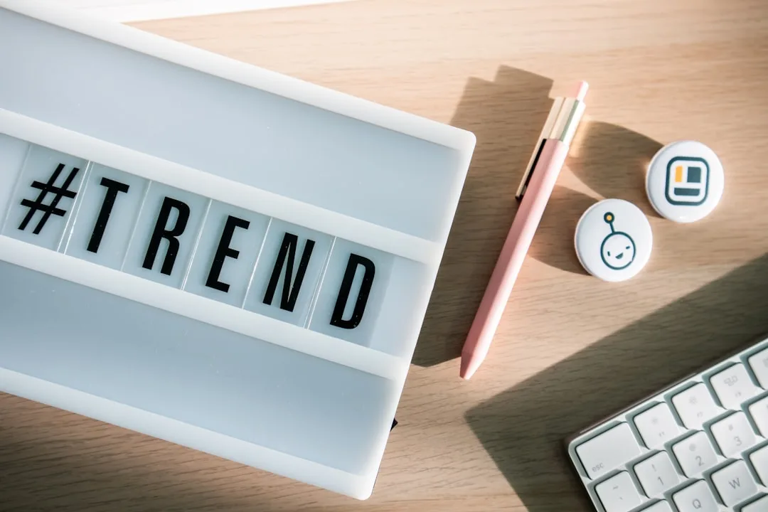 #TREND lightbox sign on wooden desk with pink pen, button badges, and white keyboard for 2024 trend analysis