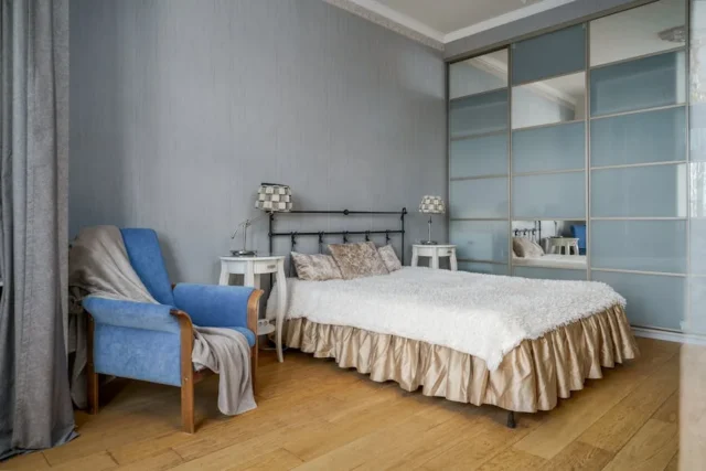 Bedroom with small white nightstand beside bed sho
