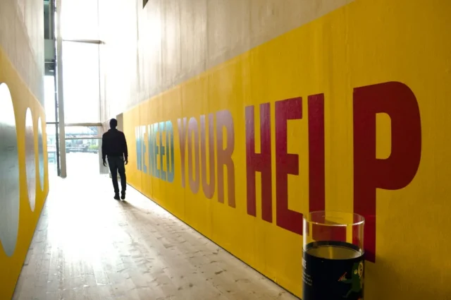 Narrow hallway with bold yellow wall mural showing