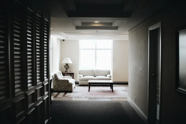 Long narrow hallway leading into a living room wit