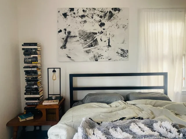 Minimalist bedroom with black metal bed frame, abs
