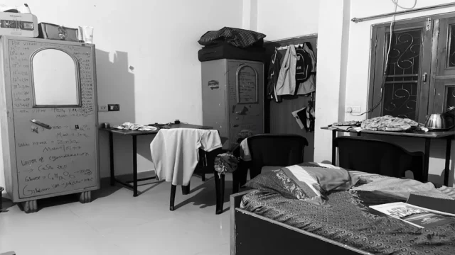 Cluttered student dorm room with mismatched furnit