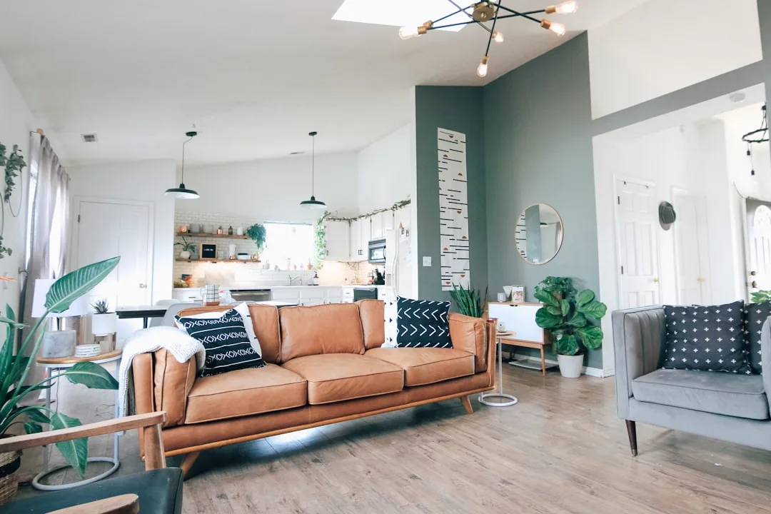 Modern boho living room with tan leather sofa, bla
