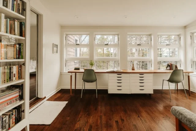 Bright minimalist home office with long wooden des