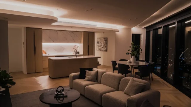 Modern open-plan apartment at night with warm ambi