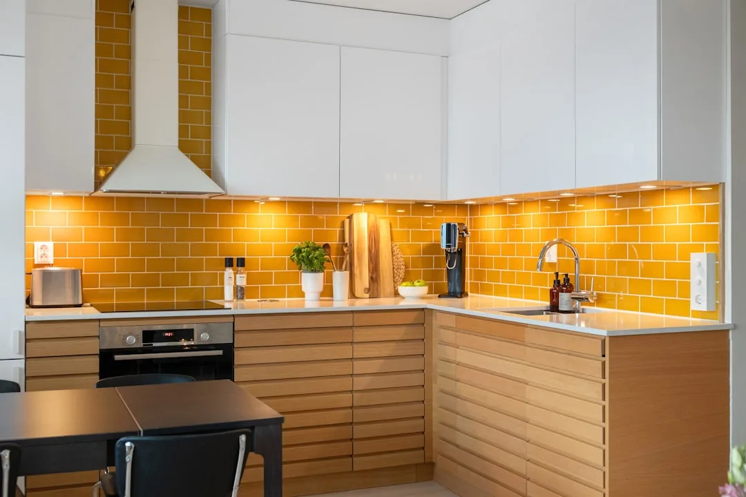 Modern kitchen with white upper cabinets, yellow s