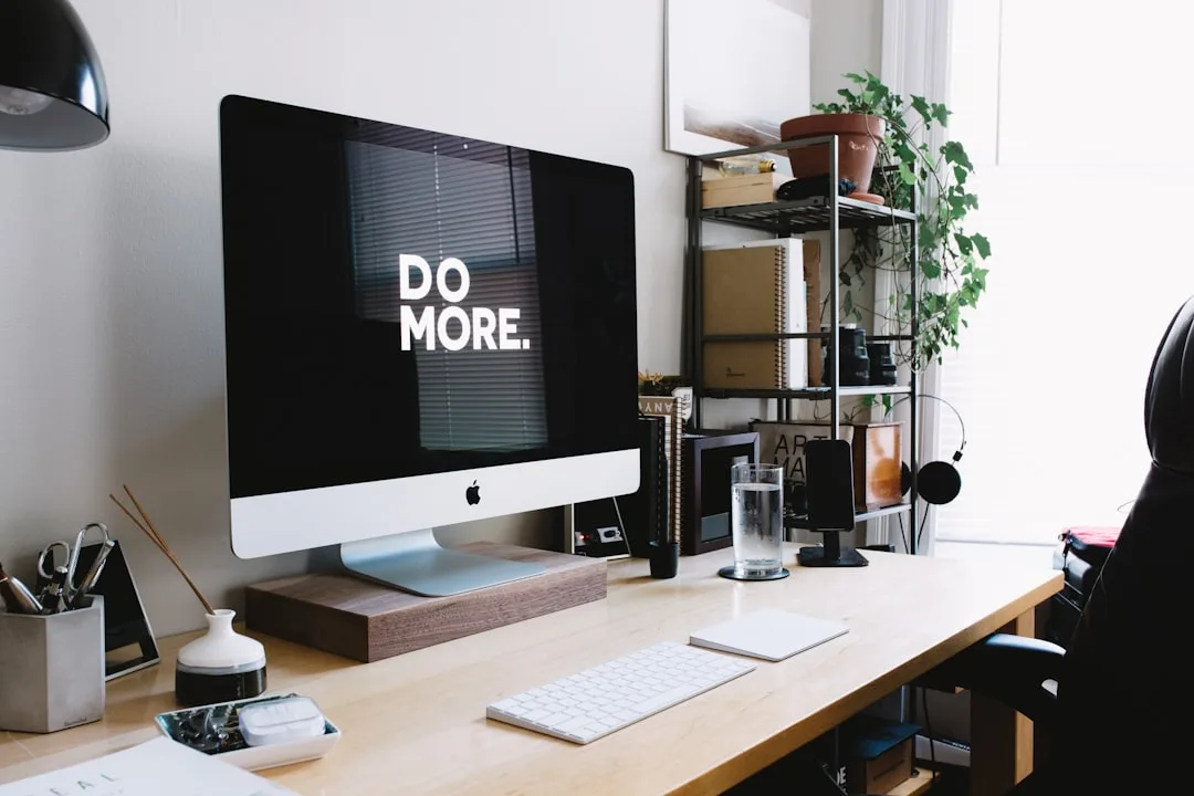 iMac desktop setup on wooden desk with Do More mot