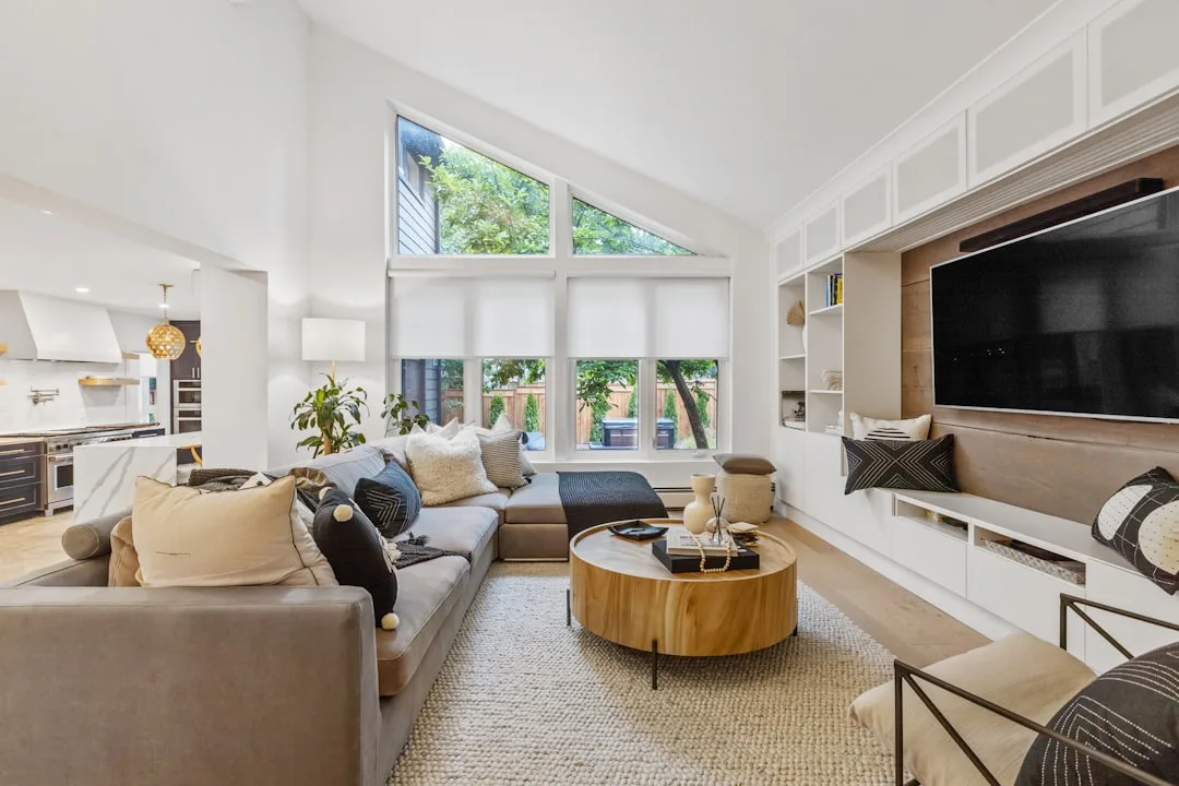 Modern living room with roller shades and clerestory windows showcasing minimalist window treatment trends in 2026