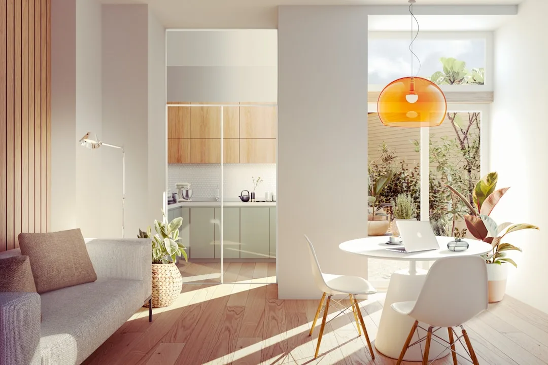 Open-plan apartment with distinct living, dining work zone and kitchen area separated by architectural columns
