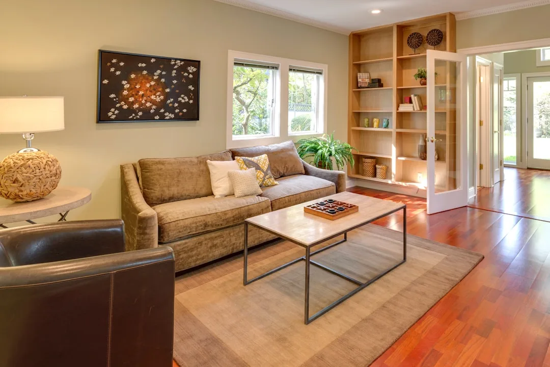 Living room with built-in floor-to-ceiling wooden bookshelves and open hardwood floor space for comfortable living
