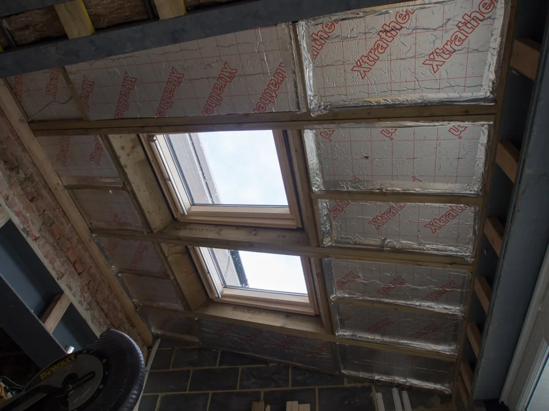 Xtratherm insulation boards fitted between roof rafters with Velux skylights during weatherproofing installation