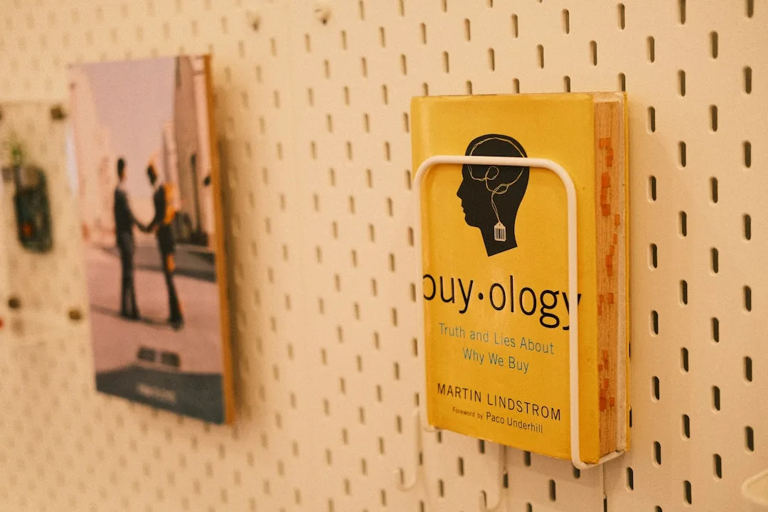 White metal pegboard wall with book holder displaying Buyology by Martin Lindstrom showing modern pegboard storage use