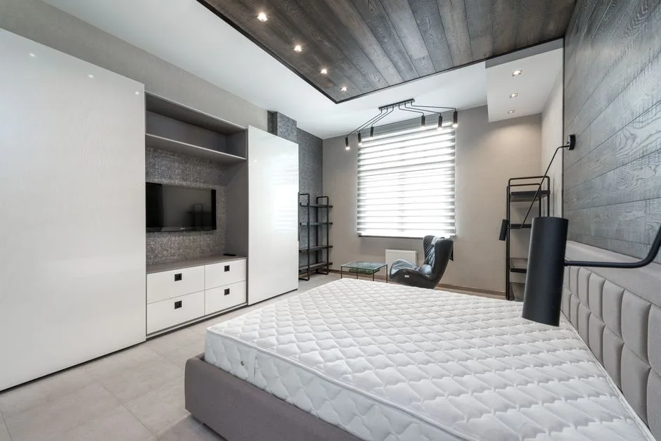 Modern bedroom with queen mattress on platform bed showing floor space usage in small room with built-in wardrobe