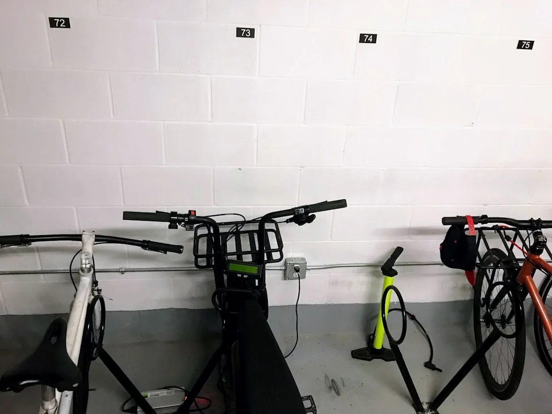 Bikes stored against numbered wall spaces 72-75 in indoor garage with cargo bike and road bike parked on floor