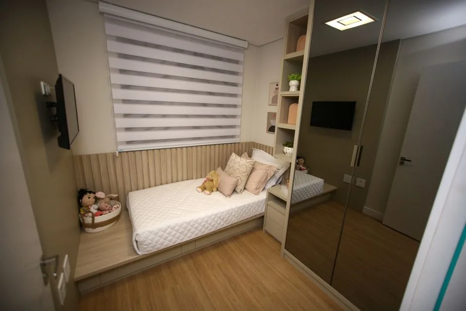 Small bedroom with platform bed, mirrored wardrobe, and built-in shelving showing smart furniture clearance layout