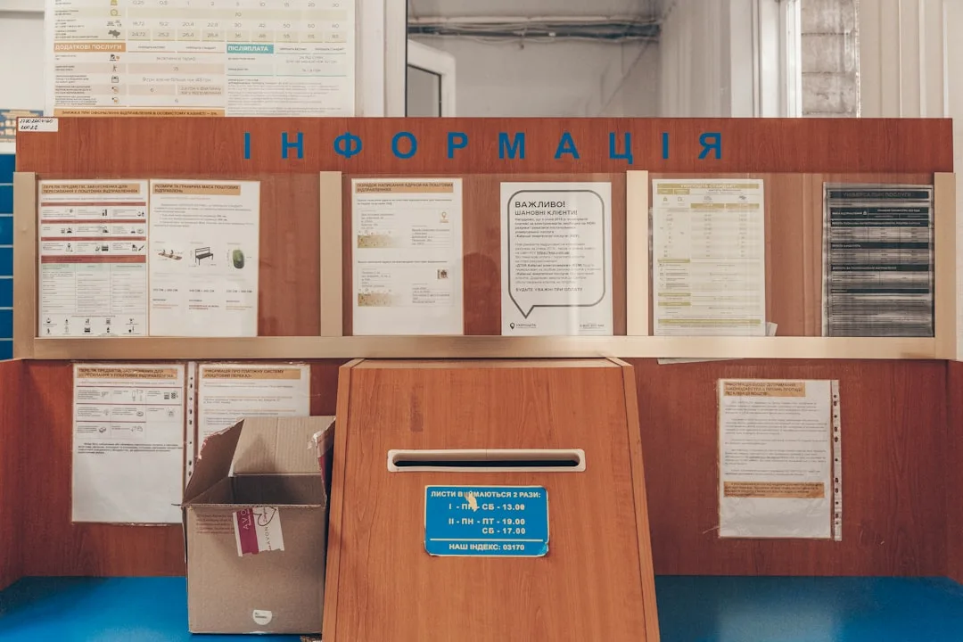 Ukrainian post office information board with mailbox and paper documents organized on wooden display wall