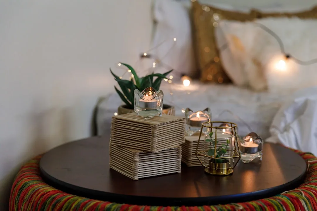 DIY room decor with tea light candles, geometric gold lantern, popsicle stick boxes, and succulent on round coffee table