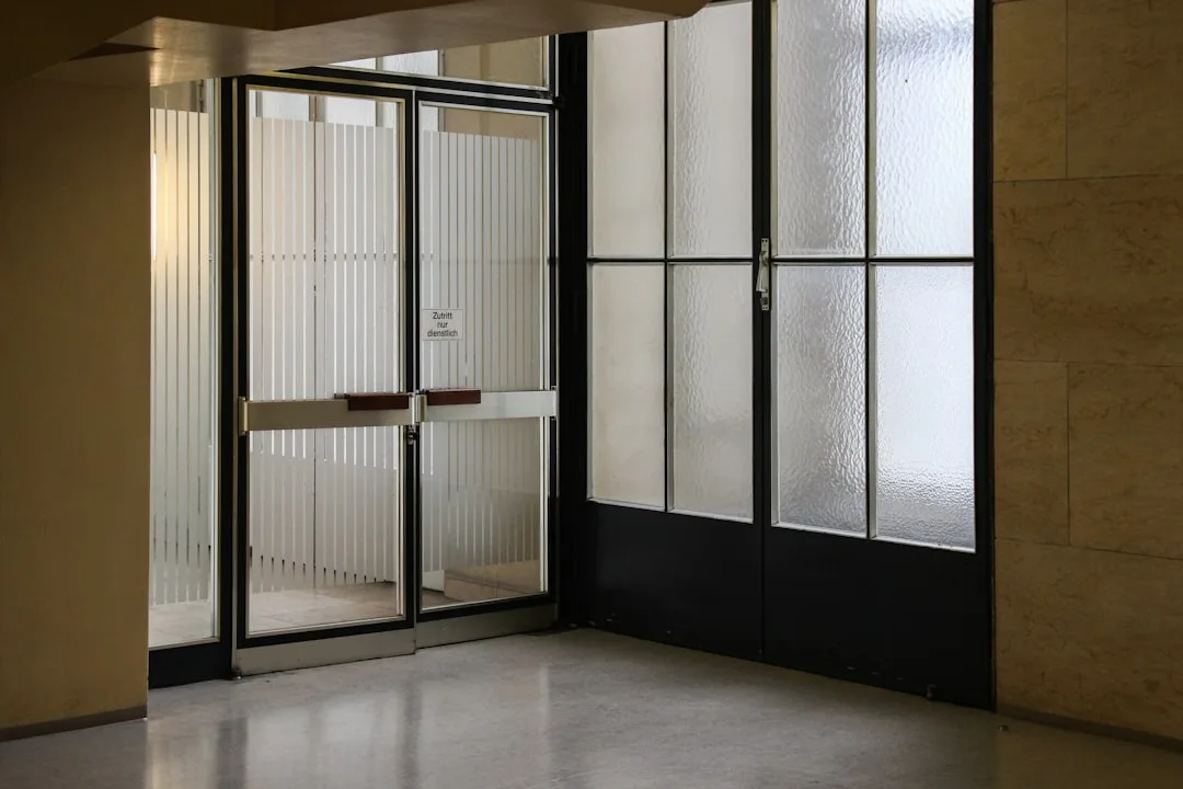 Frosted and reeded glass panel doors in a commercial hallway showing privacy with borrowed light design