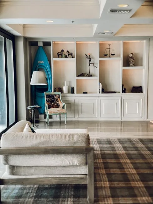 Spacious living room with white built-in shelving, cream sofa, plaid rug, and eclectic decor demonstrating furniture sca
