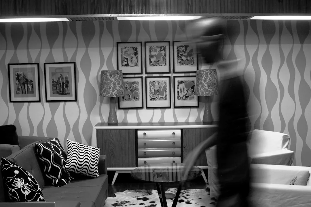 Blurred motion of person walking through mid-century modern living room in black and white photography