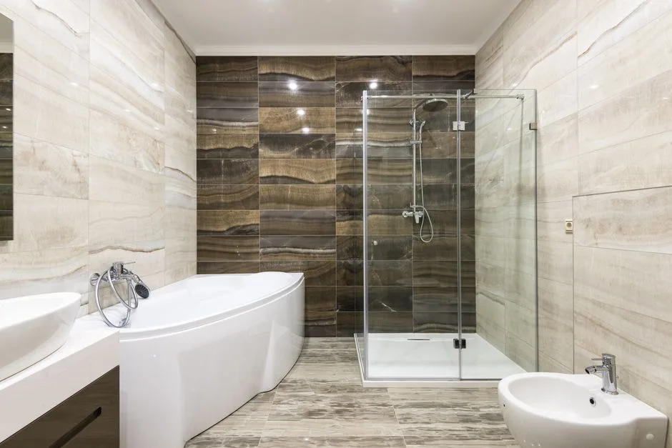 Modern luxury wet room with freestanding bathtub, glass shower enclosure, bidet, and dramatic dark marble feature wall t