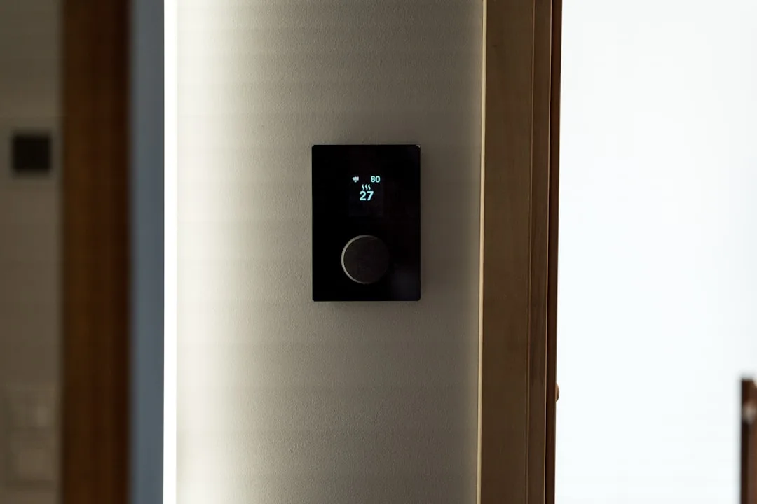 Smart LED-compatible dimmer switch mounted on wall showing temperature and WiFi display with rotary knob control