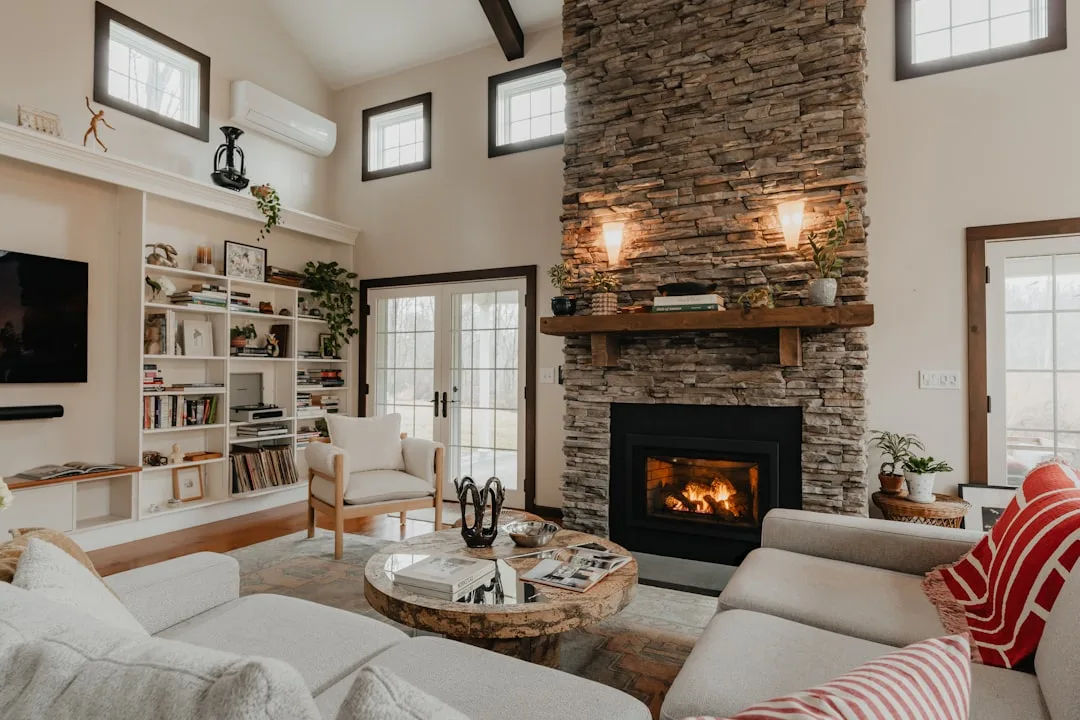 Built-in white bookshelves beside a floor-to-ceiling stone fireplace in a cozy living room